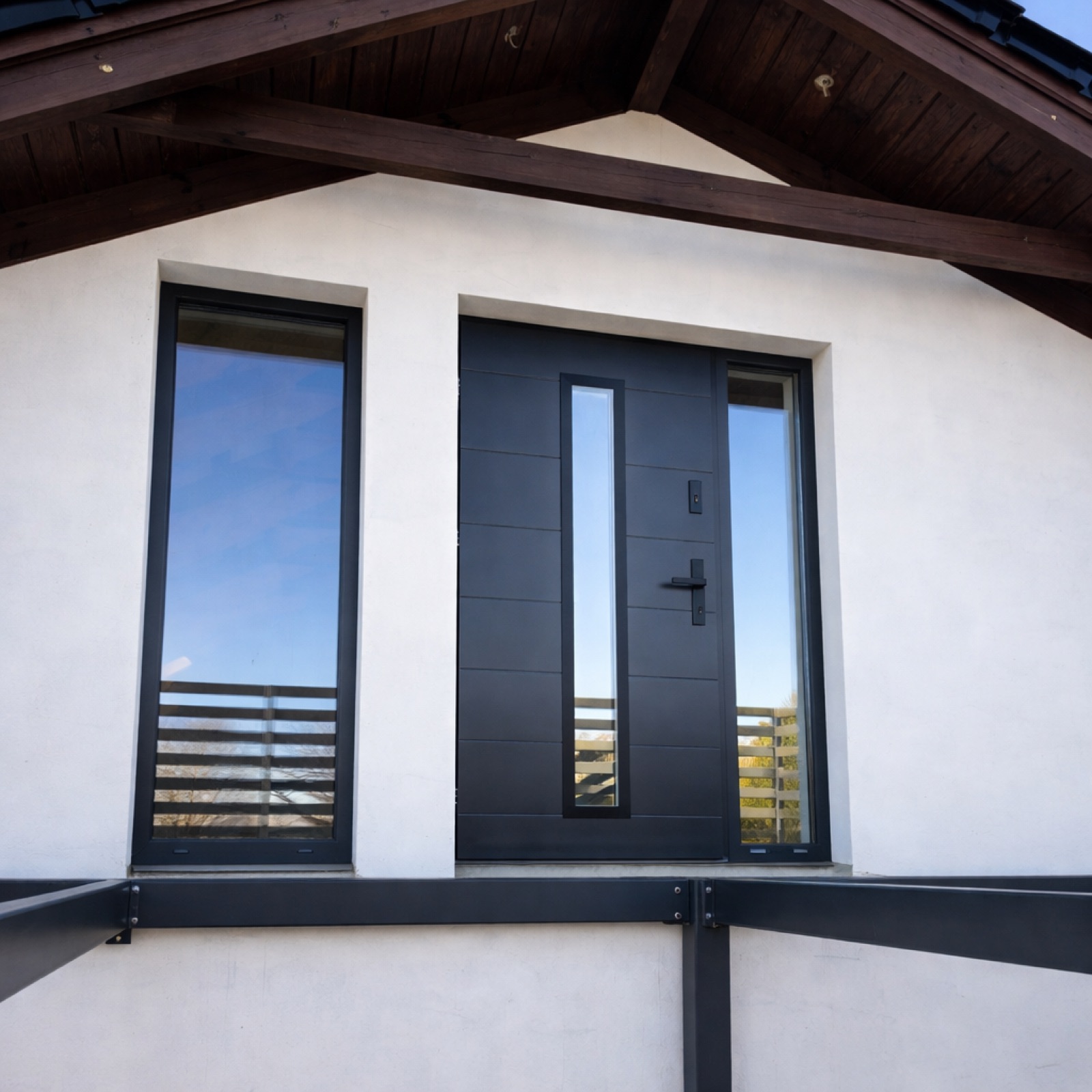 A black composite entrance door with a slim glazed sidelight